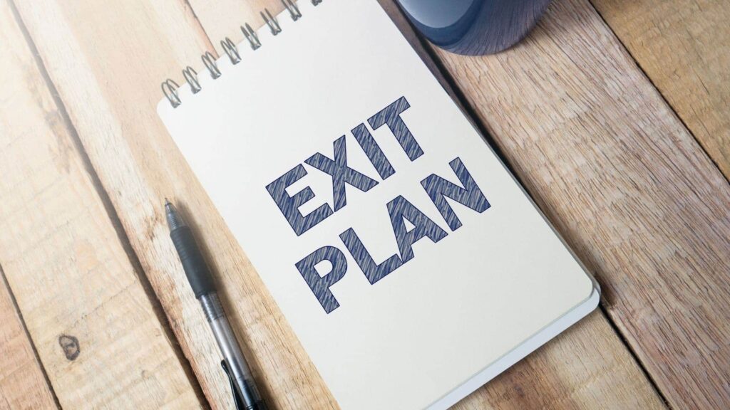 notebook on which "EXIT STRATEGY" is written in big block letters