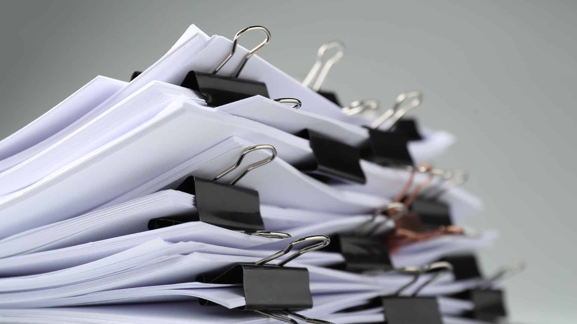 stack of papers, segmented into small bundles with metal binder clips