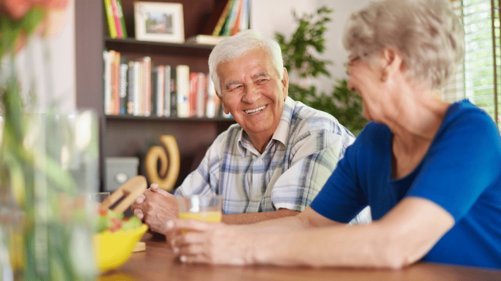 Elderly couple in a law office smiling and laughing.